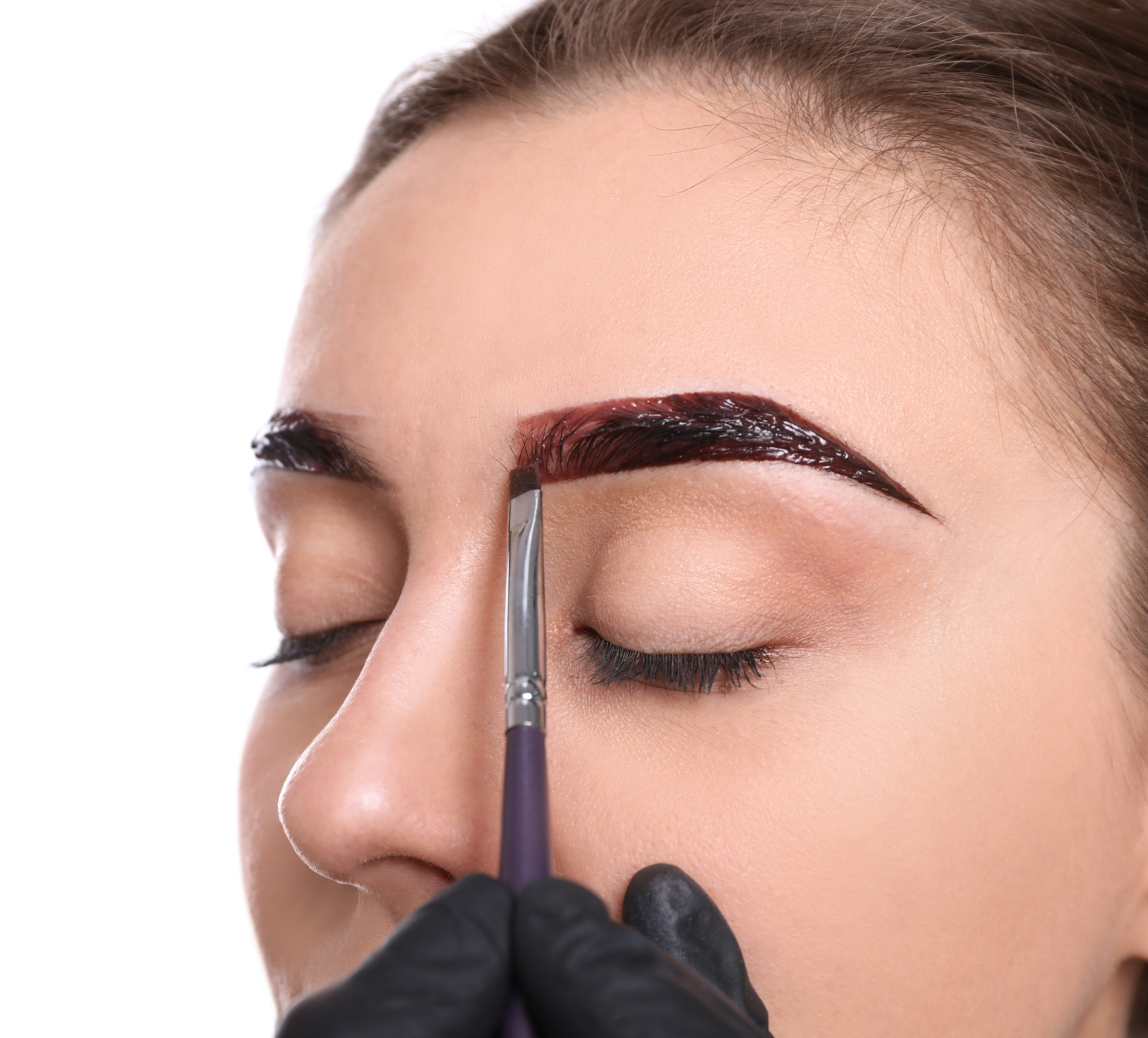 Beautician Applying Tint during Eyebrows Correction Procedure on